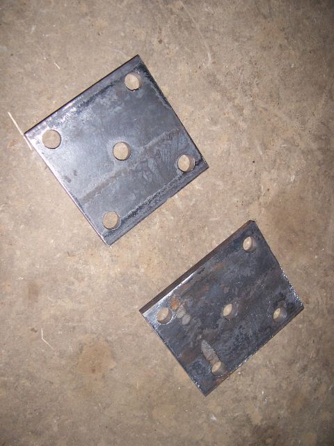 1983 Ford Bronco - These two metal plates, each with four drilled holes, are shown on a concrete surface.