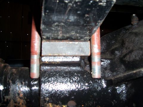 1983 Ford Bronco - Detail of vehicle suspension hardware, showing bolts and a spacer block.