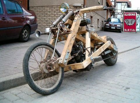1995 Ford Bronco - A homemade motorcycle constructed primarily from wood is parked on a cobblestone street.