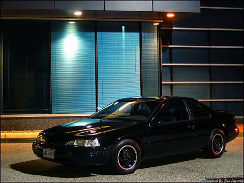 1997 Ford Thunderbird - Black 1997 Ford Thunderbird parked in front of a modern building.