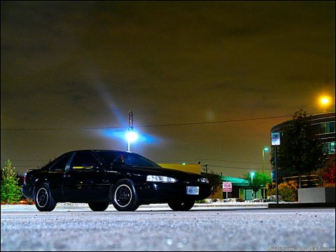 1997 Ford Thunderbird - Black 1997 Ford Thunderbird parked outdoors at night under artificial lighting.