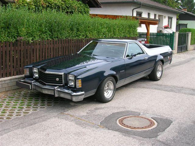 Dark blue 1977 Ford Ranchero parked on a street in front of a house
