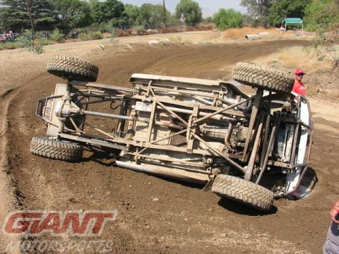 1984 Ford Bronco - This off-road vehicle has rolled over on a dirt track, exposing its undercarriage.