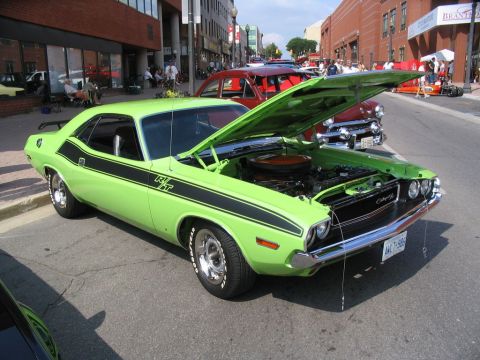 1993 Ford Taurus - A lime green 1970 Dodge Challenger R/T is displayed with its hood open at a car show.