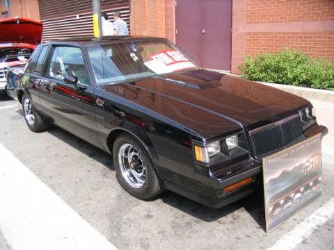 1993 Ford Taurus - A black coupe is displayed at a car show with a 'for sale' sign and a poster in front.