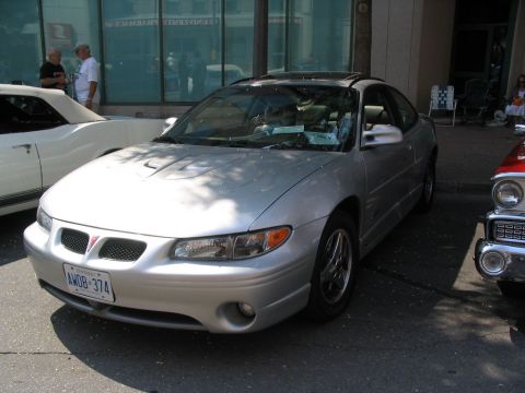 1993 Ford Taurus - Silver 1997 Pontiac Grand Prix GTP parked at a car show, showing its front 3/4 view and sunroof.