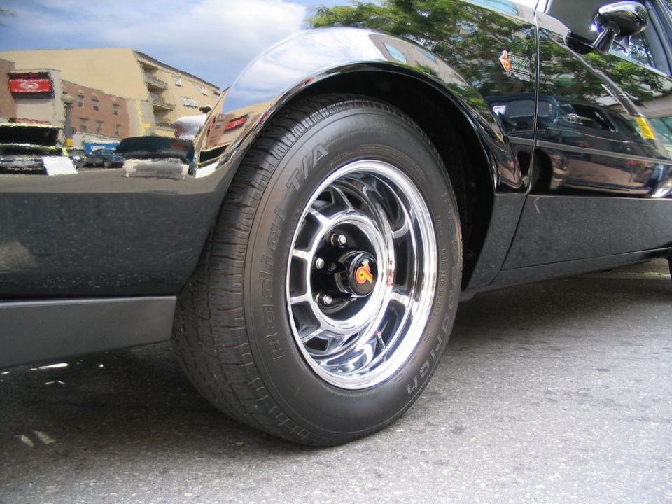 close-up of a black car's front wheel and fender