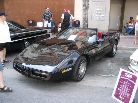 1993 Ford Taurus - A black convertible with a red interior is displayed at a car show, identified as an 'Official Pace Car'.