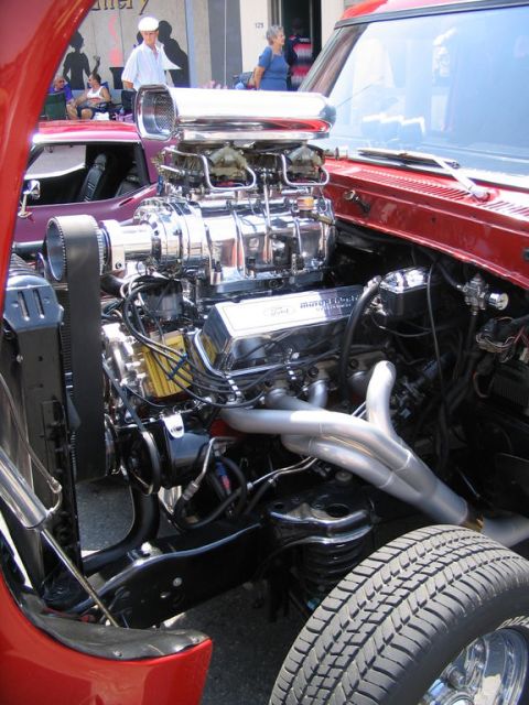 1993 Ford Taurus - Engine bay of a red vehicle with a prominent supercharger and exhaust headers is displayed.