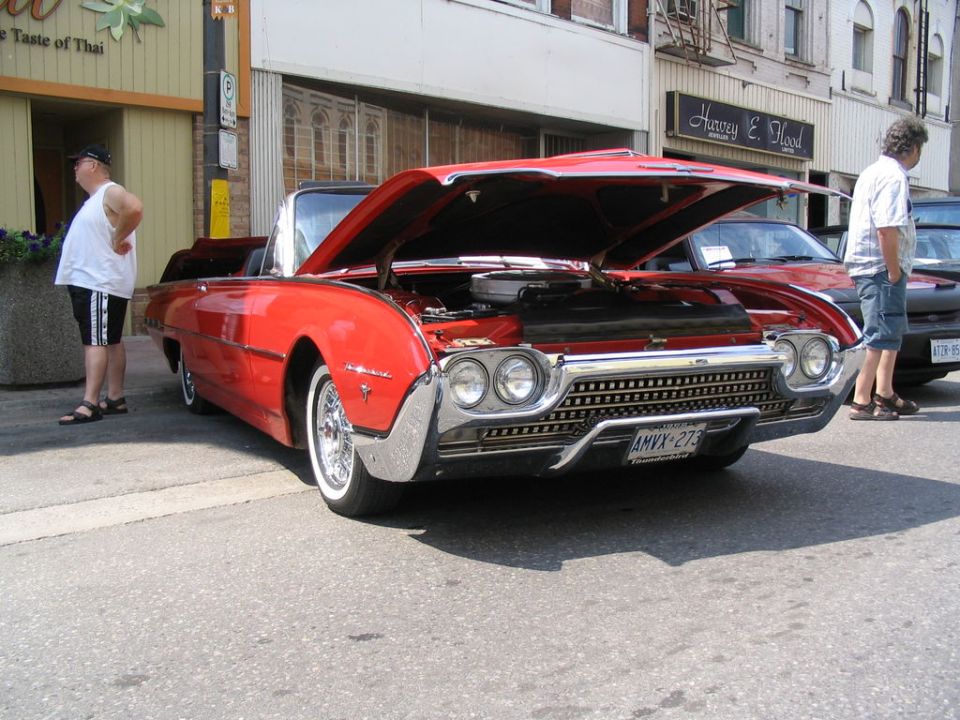 Red 1961 convertible with hood open, showing engine and front grille. License plate AMVX-273