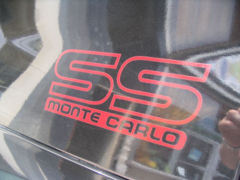 1993 Ford Taurus - Close-up of a red SS Monte Carlo badge on a black vehicle.