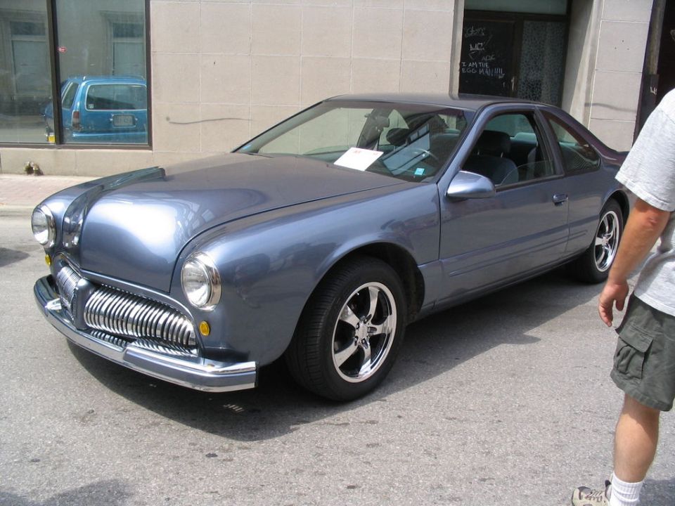 Blue coupe with a heavily customized front end resembling an older vehicle