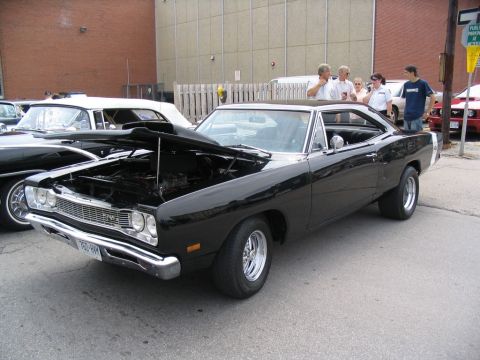 1993 Ford Taurus - A black 1969 Dodge Super Bee is displayed with its hood open at a car show.