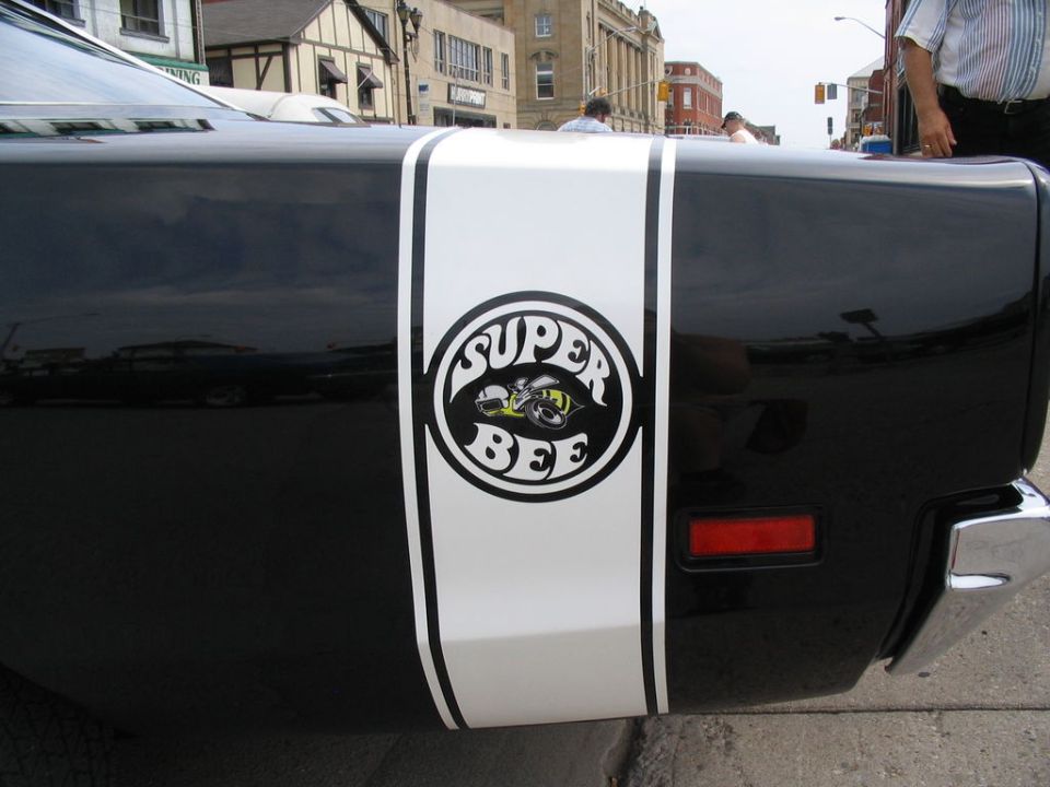 Black car rear quarter panel with white stripe and Super Bee emblem
