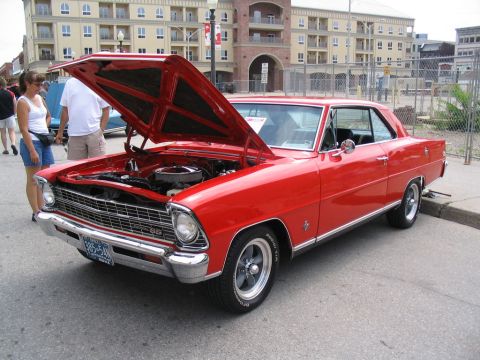 1993 Ford Taurus - 1967 Chevrolet Nova SS coupe displayed with its hood open at a car show.