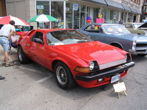 1993 Ford Taurus - A red AMC Pacer is displayed at a car show, with other vehicles visible in the background.