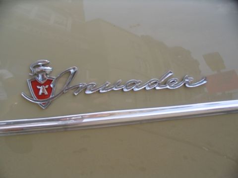 1993 Ford Taurus - Close-up of a chrome 'Invader' emblem on a vehicle, a red shield with a stylized 'A'.
