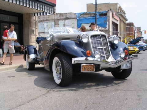 1993 Ford Taurus - A vintage convertible is displayed on a street, with other cars visible in the background.