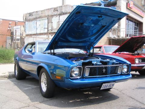 1993 Ford Taurus - A blue 1971 Ford Mustang is displayed with its hood open, alongside another vehicle.