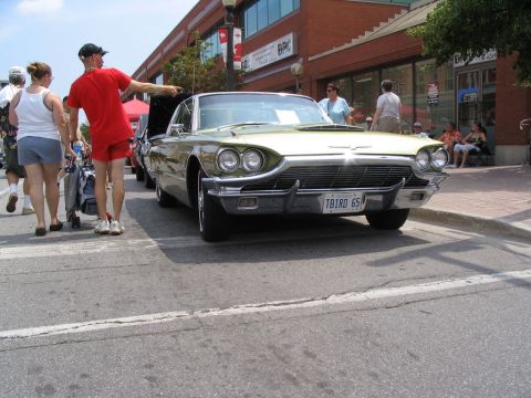 1993 Ford Taurus - A 1965 Ford Thunderbird is displayed at a car show, its front grille and headlights clearly visible.