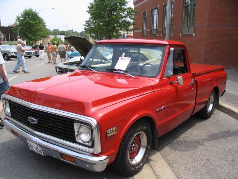 1993 Ford Taurus - A classic red pickup truck is on display at a car show.