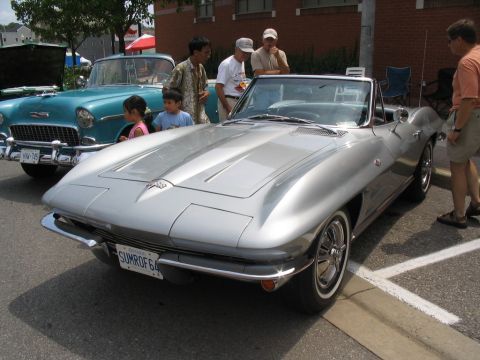 1993 Ford Taurus - A silver 1964 Corvette convertible is displayed at a car show, with another classic car visible behind it.