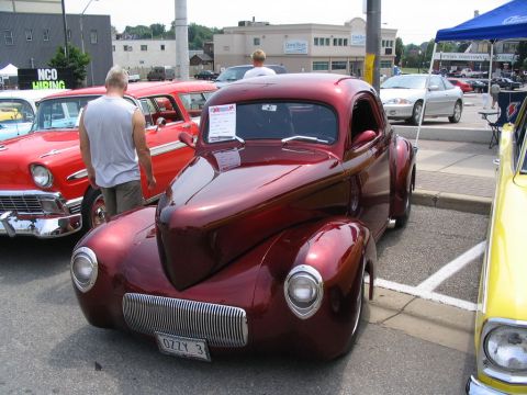 1993 Ford Taurus - A custom hot rod coupe is displayed at a car show, parked alongside other vehicles.