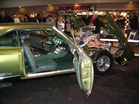 1993 Ford Taurus - This custom green muscle car features a prominent engine and detailed interior, with 'GTX' badging visible on the side.