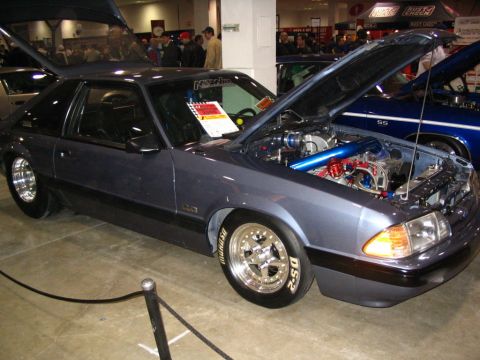 1993 Ford Taurus - Gray coupe with hood and trunk open, revealing a custom engine and drag racing tires. The vehicle's body style suggests it is not a 1993 Fo…