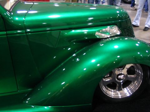 1993 Ford Taurus - A custom green hot rod is displayed indoors, showing off its shiny paint and chrome accents.