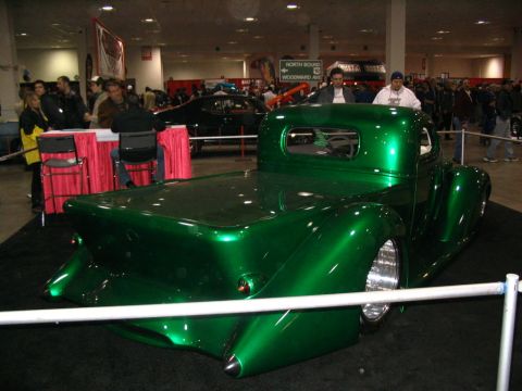 1993 Ford Taurus - Custom green hot rod pickup truck displayed indoors at a car show.