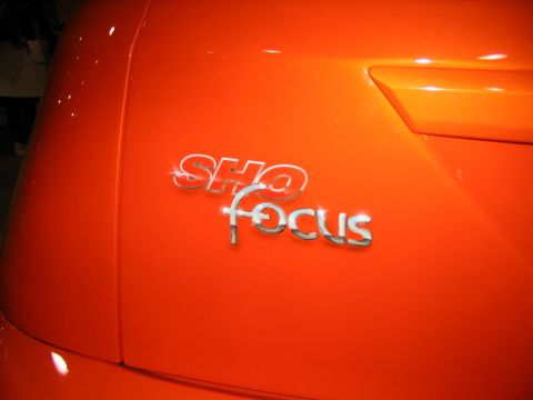 1993 Ford Taurus - The chrome SHO Focus badge is visible on the orange car's body panel.