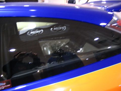 1993 Ford Taurus - A car with blue and orange paint is shown from the side, focusing on the rear window area.