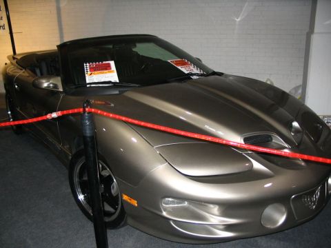 1993 Ford Taurus - A brown convertible Pontiac Firebird Trans Am is displayed indoors with a red rope barrier.