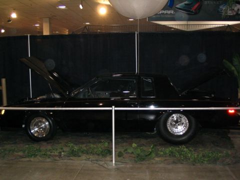 1993 Ford Taurus - This black coupe is displayed with its hood and trunk open, drag racing wheels.