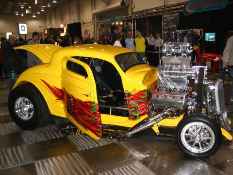 1993 Ford Taurus - Custom hot rod with exposed engine and flame graphics on doors at a show.