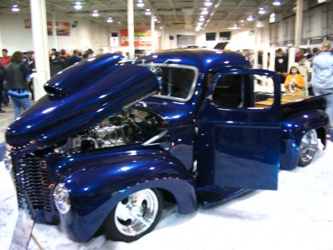1993 Ford Taurus - A custom blue pickup truck is displayed with its hood and door open, revealing the engine and interior.