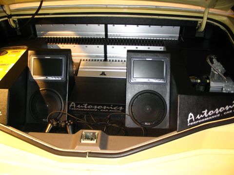 1993 Ford Taurus - The trunk of a car is outfitted with a custom audio system multiple speakers and amplifiers.