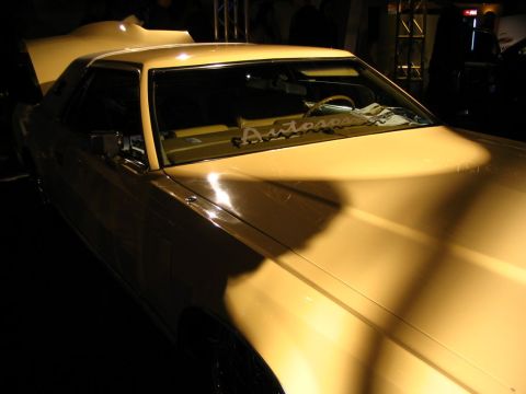 1993 Ford Taurus - A yellow coupe is displayed with its hood open, revealing the interior and dashboard.