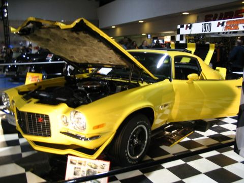 1993 Ford Taurus - This bright yellow 1970 Chevrolet Camaro Z28 is displayed with its hood and door open, revealing the engine bay.