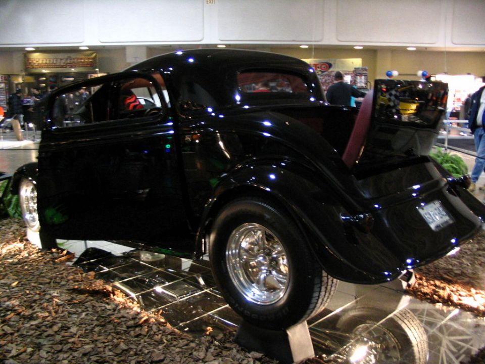 Black hot rod coupe with chrome wheels and open door