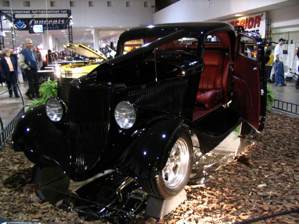 Black hot rod coupe with red interior, open door, on display