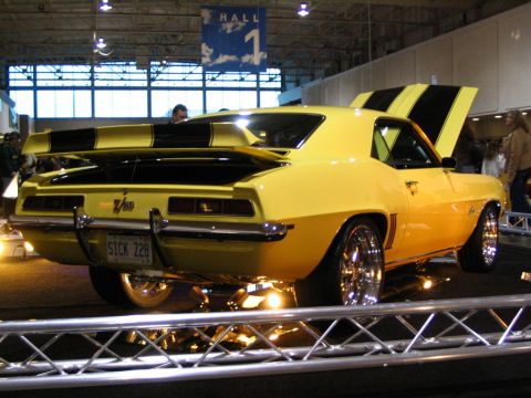 1993 Ford Taurus - A bright yellow 1969 Chevrolet Camaro Z/28 is displayed indoors with its hood open and black racing stripes.