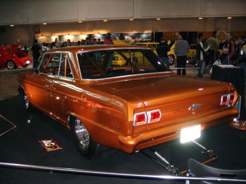 1993 Ford Taurus - This customized classic car features a roll cage and a bright orange paint job, displayed indoors.