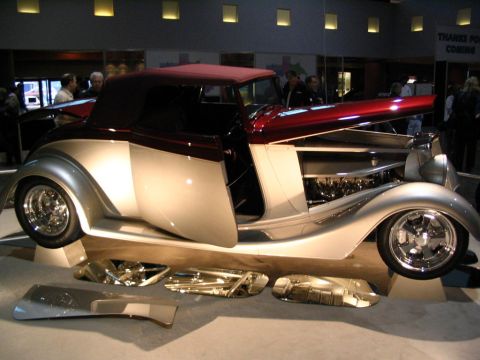 1993 Ford Taurus - A custom hot rod convertible is displayed with its hood open and chrome parts laid out in front.