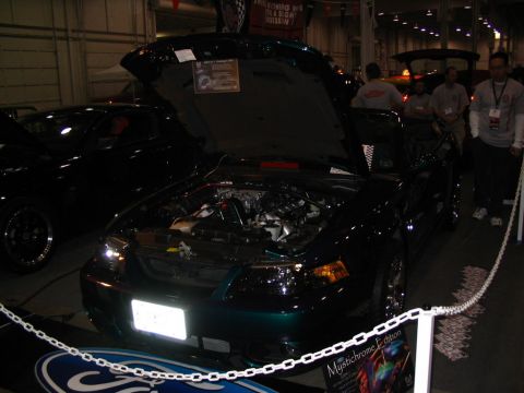 1993 Ford Taurus - Ford Mustang with its hood open, displaying the engine bay. A sign indicates it's a Mystichrome Edition.
