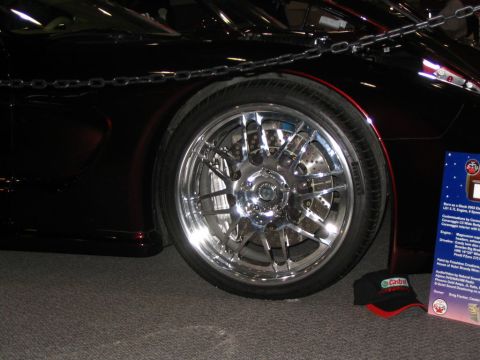1993 Ford Taurus - A customized car's wheel and fender are shown, with a descriptive sign and a hat on the floor.