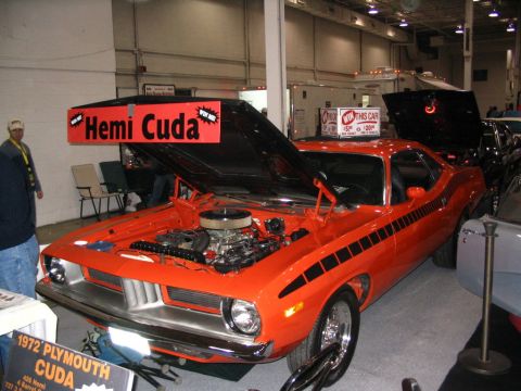 1993 Ford Taurus - Orange 1972 Plymouth Barracuda displayed with its hood open, a prominent 'Hemi Cuda' banner.