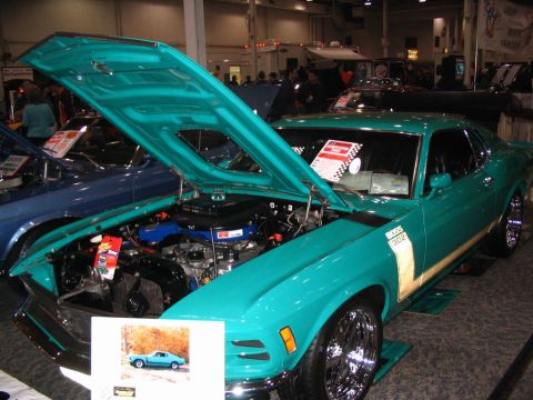 1993 Ford Taurus - A teal 1969 Ford Mustang Boss 302 is displayed with its hood open, revealing the engine and a small inset photo of the car.