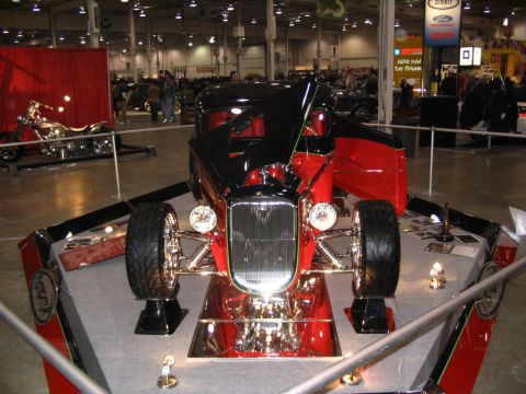 1993 Ford Taurus - A custom hot rod is displayed indoors, a prominent grille and red interior.